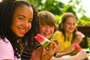 Middle school students eating watermelon