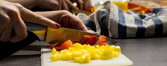 Close up of hands chopping vegetables